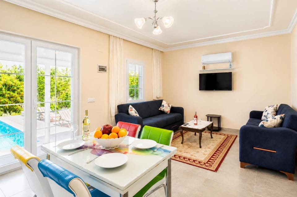Open-plan living room with sofas, dining area, kitchen, A/C, WiFi internet, satellite TV, and terrace access