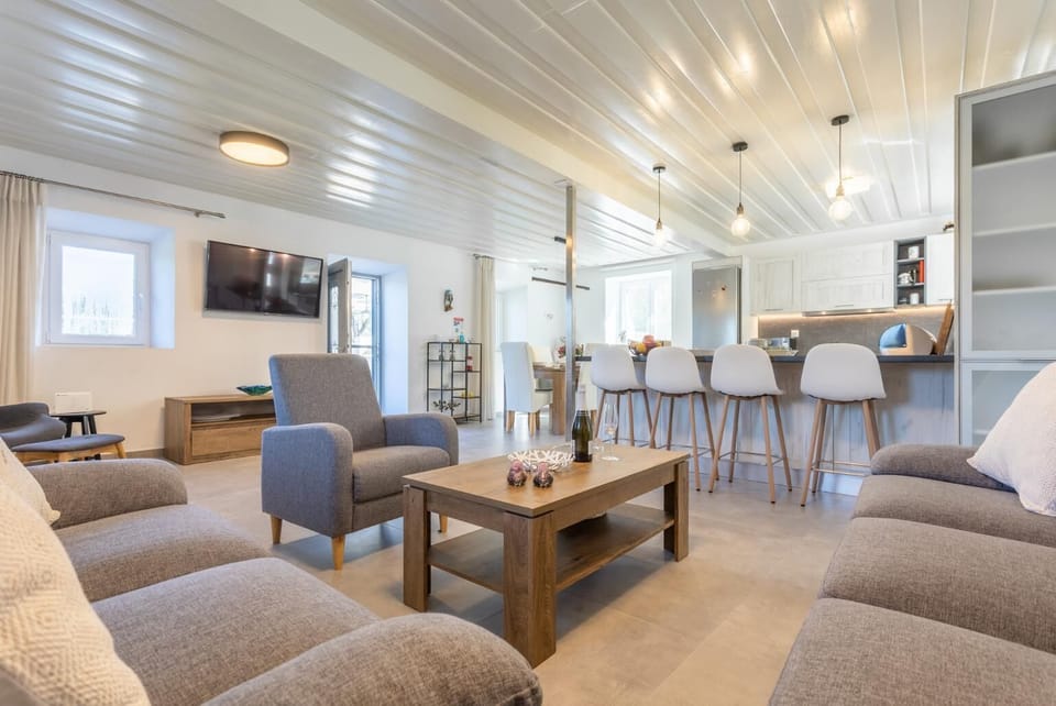 Open-plan living room with sofas, dining area, kitchen, WiFi internet, and satellite TV