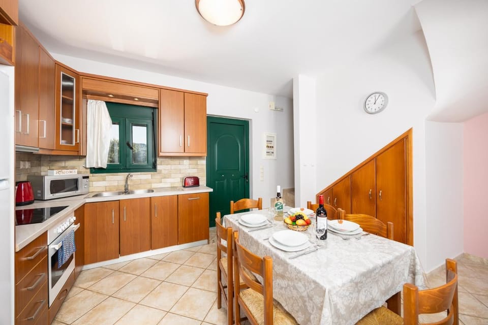 Open-plan living room with sofas, dining area, kitchen, A/C, WiFi internet, and satellite TV