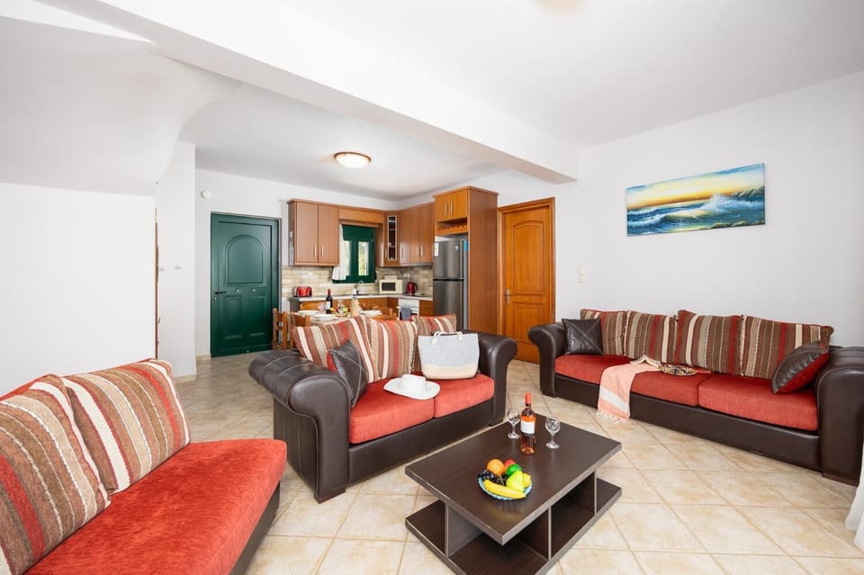 Open-plan living room with sofas, dining area, kitchen, A/C, WiFi internet, and satellite TV