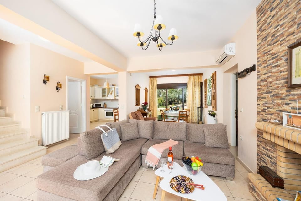 Open-plan living room with sofa, dining areas, kitchen, ornamental fireplace, A/C, WiFi internet, A/C, and satellite TV