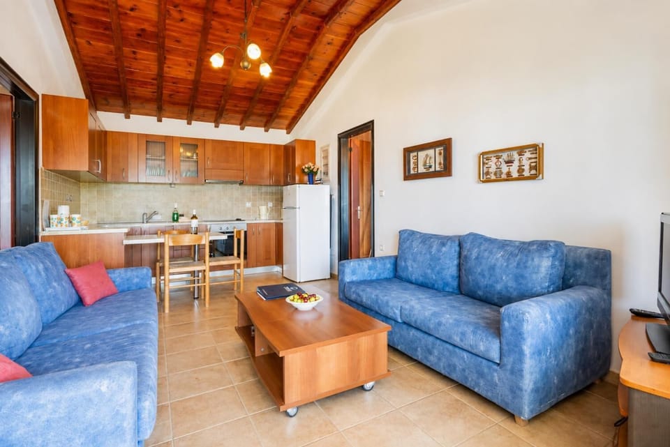 Open-plan living room with sofas, dining area, kitchen, satellite TV, WiFi Internet, DVD player, and terrace access