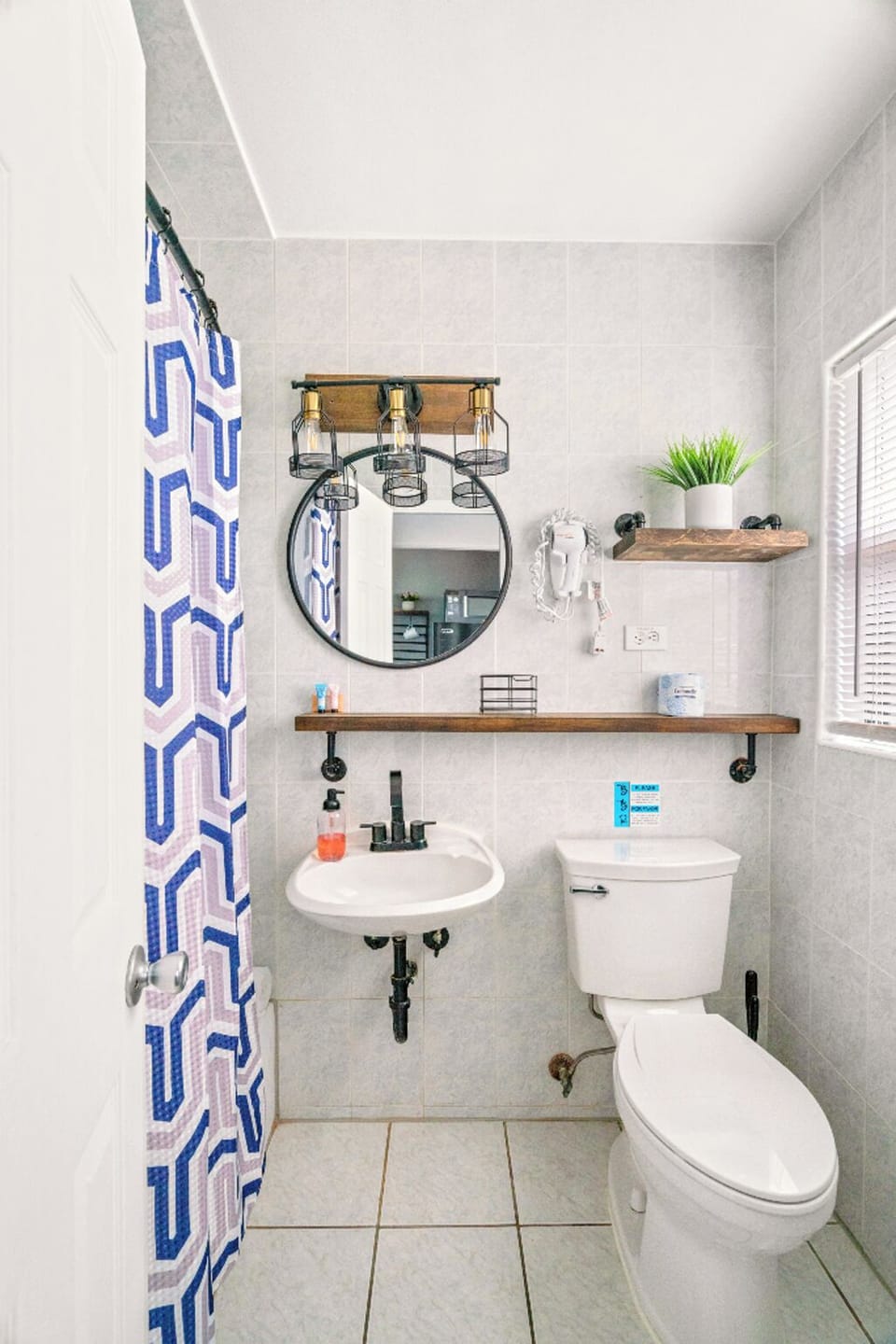 Boutique Beach Retreat tiled full bathroom Shower and tub Hair dryer, sink, toilet, Great natural lighting and storage.