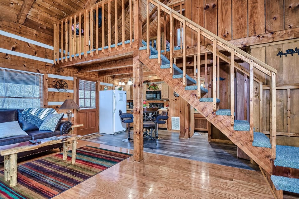 Looking through the living room toward the kitchen and loft above