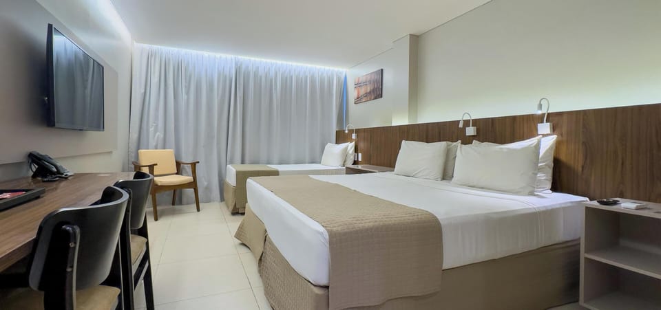 Deluxe Triple Room | Minibar, in-room safe, desk, laptop workspace