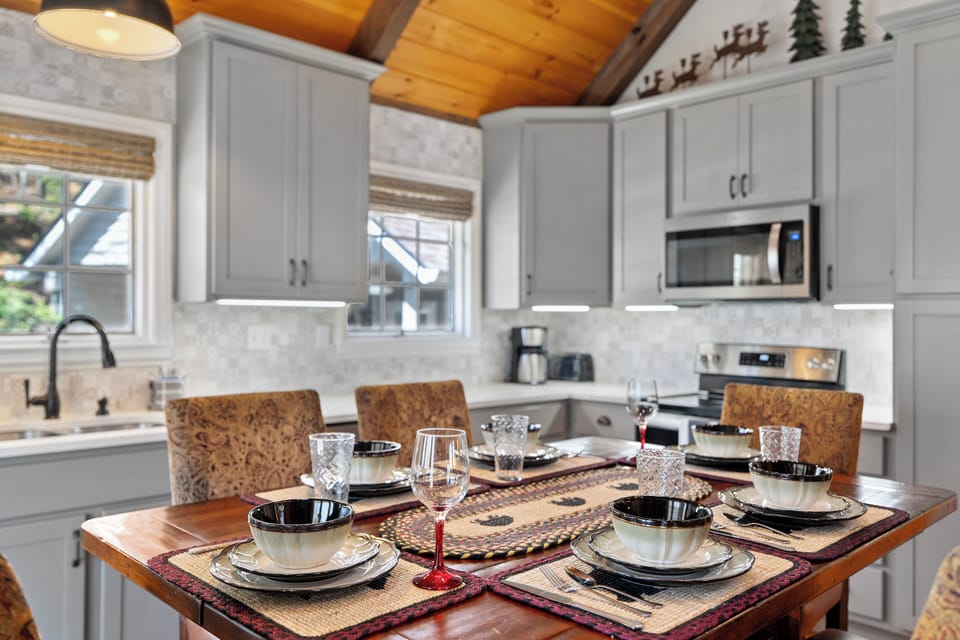 Cozy dining area set for a meal, surrounded by a bright modern kitchen.