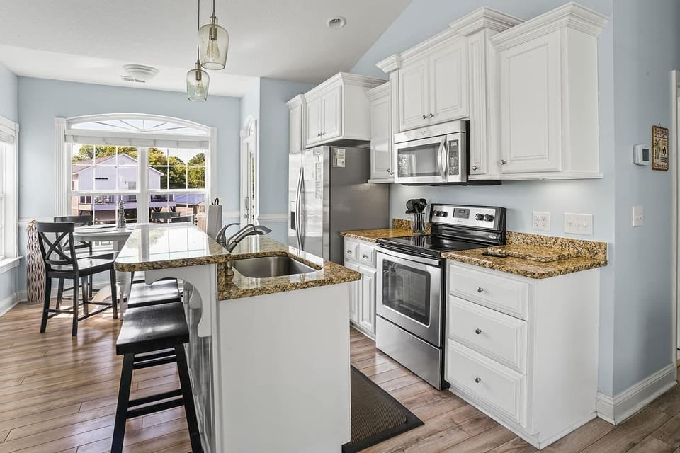 Bright, modern kitchen with cozy breakfast nook and stainless steel appliances