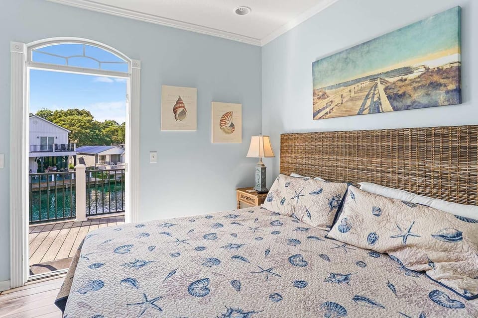Cozy bedroom with coastal decor and balcony views