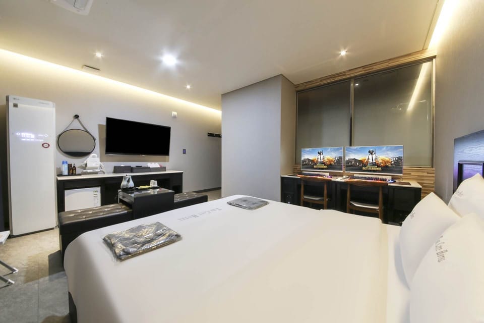 Couple PC room | Premium bedding, down comforters, desk, laptop workspace