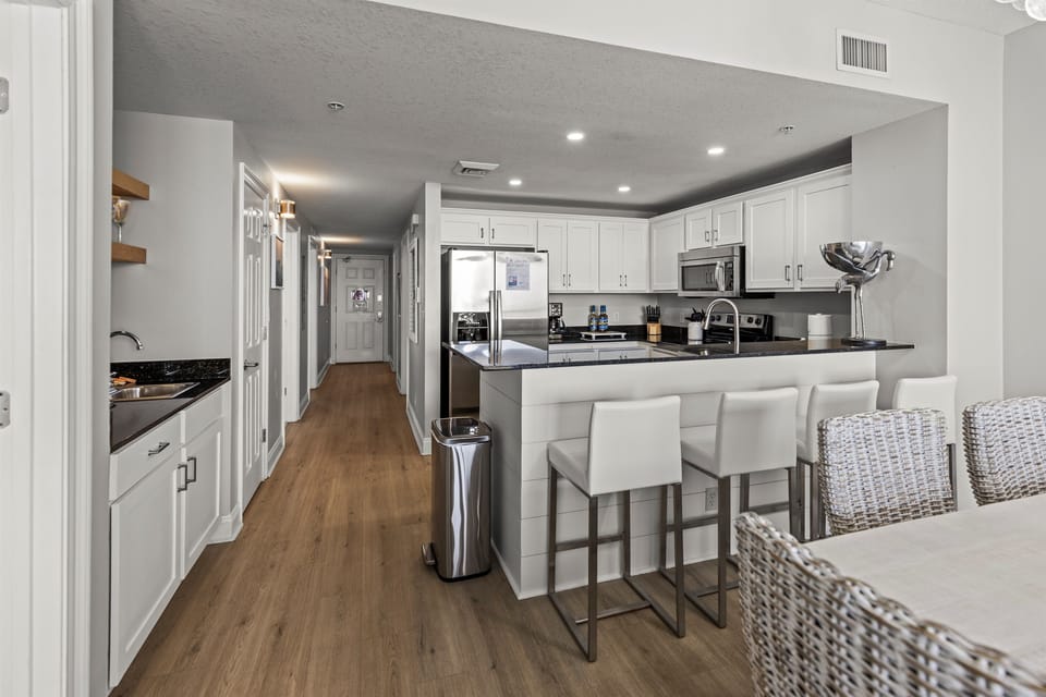 Your stylish kitchen awaits with gleaming granite counters, stainless steel appliances, and a breakfast bar perfect for morning coffee or evening conversations.