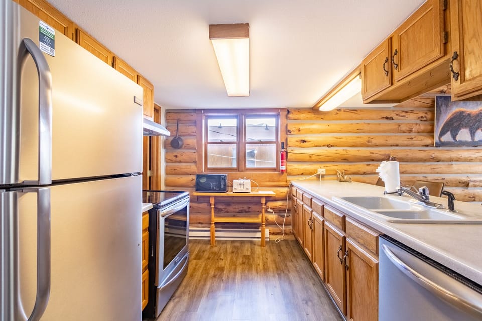 Prepare meals in your fully equipped log cabin kitchen with stainless steel appliances and warm wood surroundings.