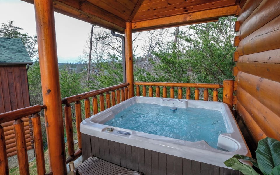 Relax in the hot tub on the covered deck with serene wooded views.
