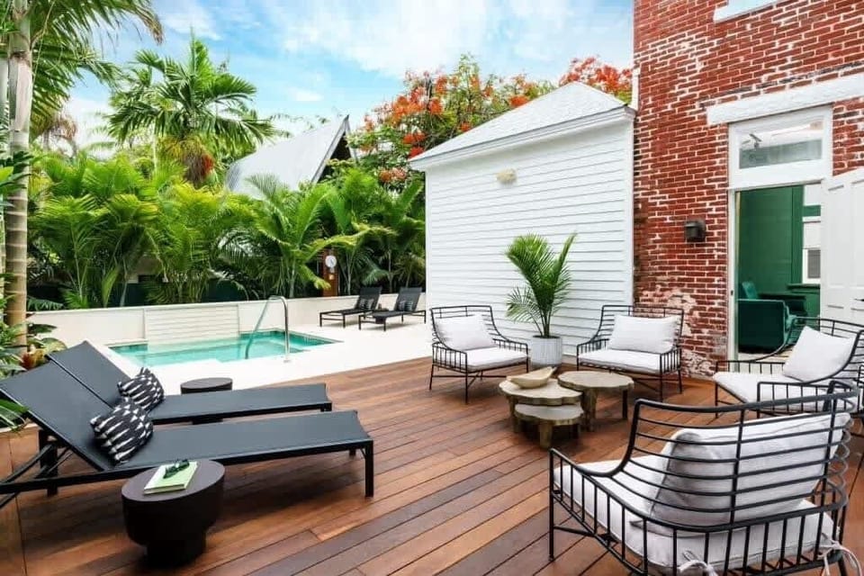 Heated pool surrounded by lush greenery and luxury outdoor seating.