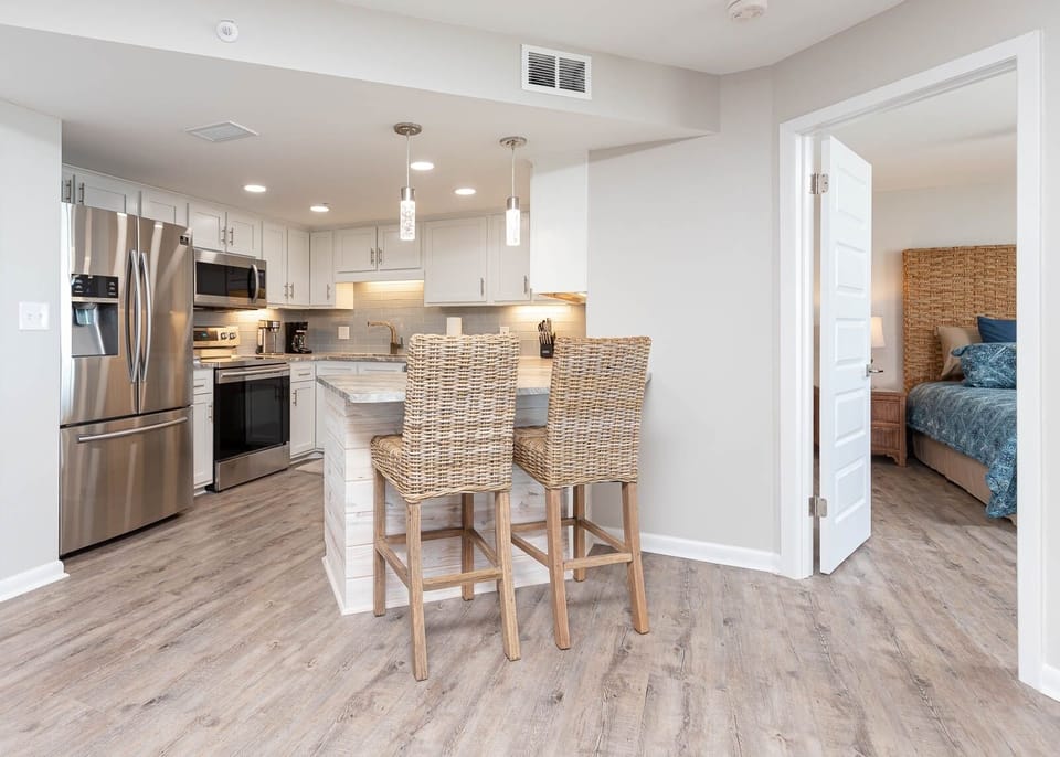 Gather around the kitchen with bar stools for casual dining, surrounded by stylish cabinetry and stainless appliances