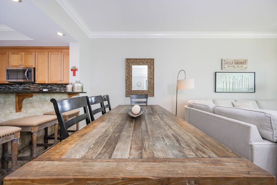 Gather around the rustic dining table, surrounded by inviting decor and a cozy living area for a relaxing meal