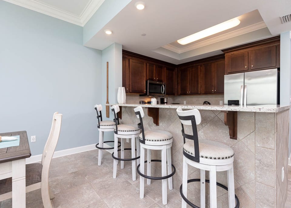 Chat and enjoy cocktails gathered around the inviting breakfast bar, with coastal decor enhancing your experience