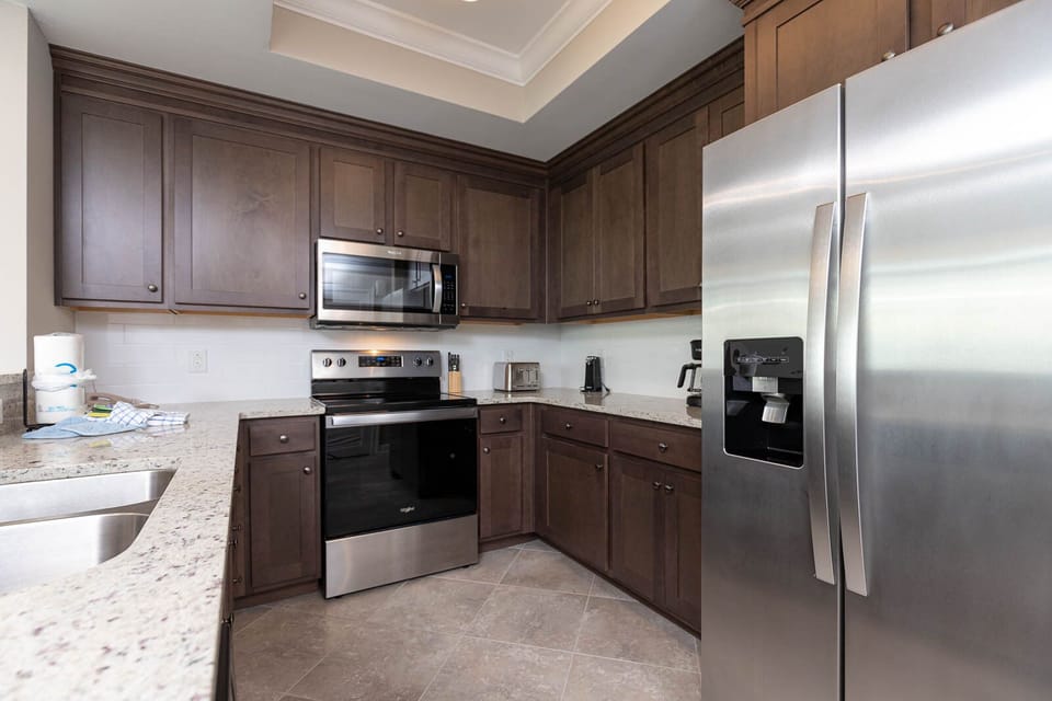Prepare meals in this kitchen with elegant cabinetry, stainless appliances, and spacious countertops