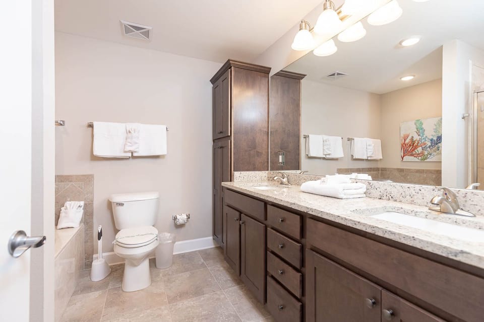 Refresh in the master bath after a day at the beach with a soothing tub and relaxing walk-in shower