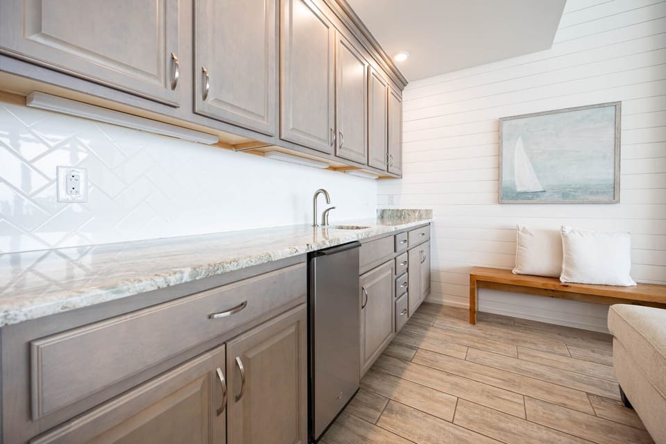 Prepare refreshing drinks at the wet bar, enjoying the beachy atmosphere as you unwind in this inviting space
