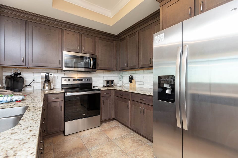 Create delicious meals in this kitchen, equipped with stainless appliances, rich wooden cabinetry, and coffee corner