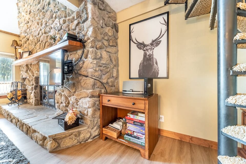 Cozy up beside your rustic stone fireplace with charming décor and entertainment center for perfect evenings in.