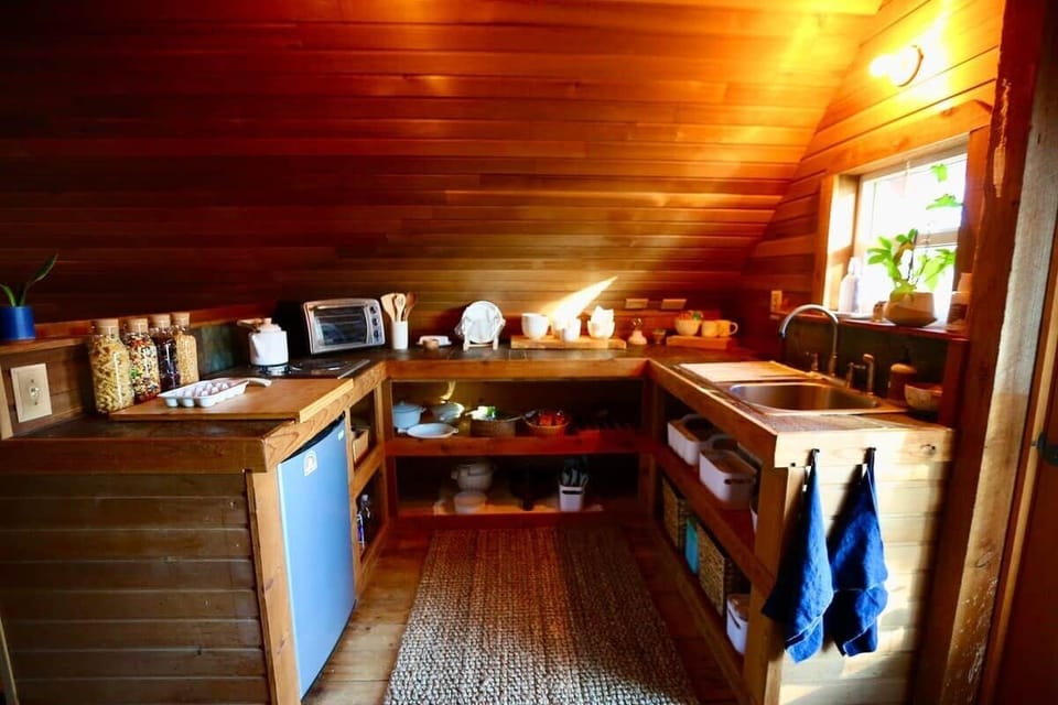 Kitchen, has stove top, mini fridge, toaster oven, stove top and plenty of dishes