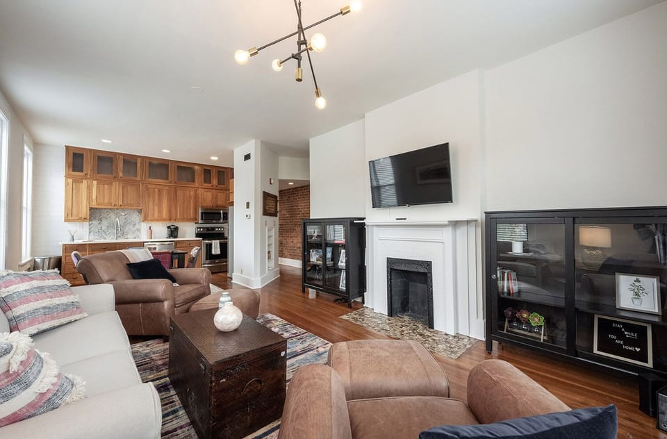 Living room with 46 inch TV attached to ROKU. Snuggle up in a leather chair.