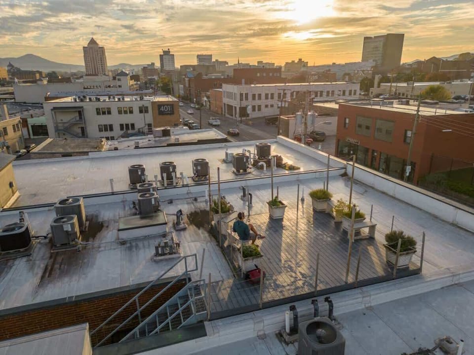 Rooftop patio with tables and city views