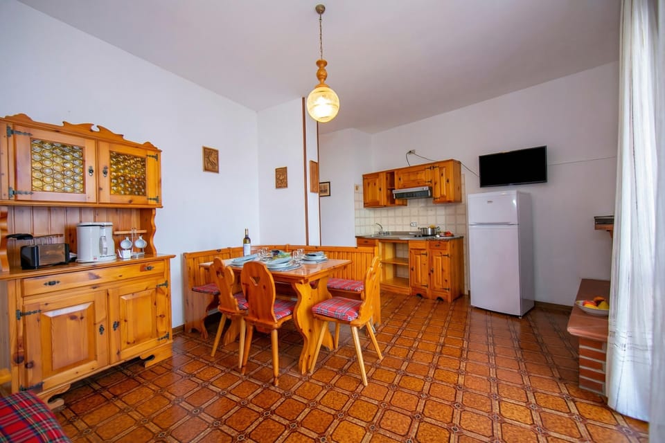 The living room with dining table and view of the kitchen