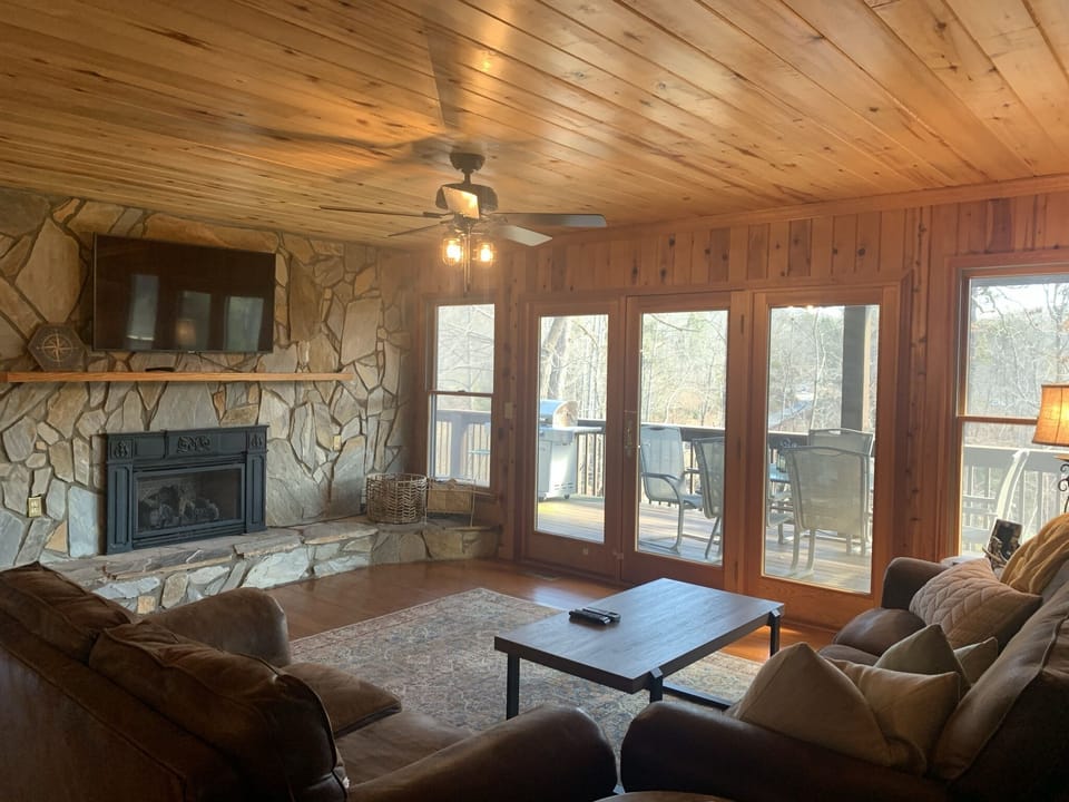 Beautiful stone fireplace with gas fire. Doors to covered deck and seating