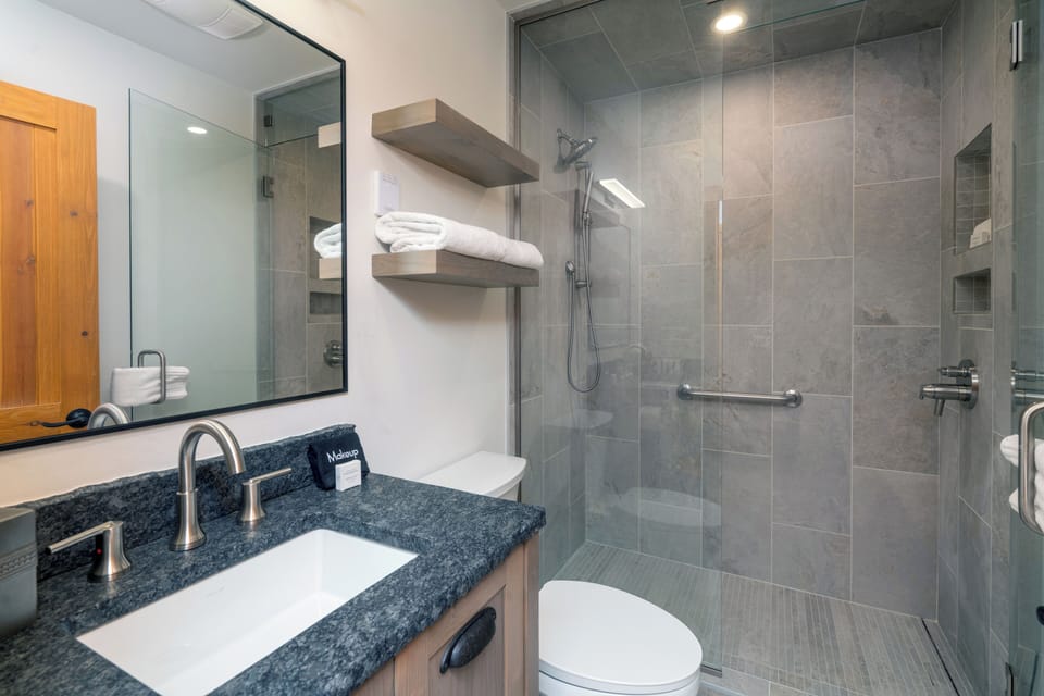 Refresh in your modern bathroom with granite counters, glass shower, and fresh towels awaiting your arrival.