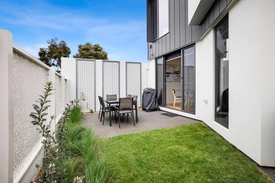 The outdoor area is a sunlit oasis, perfect for enjoying a BBQ or simply relaxing with a good book