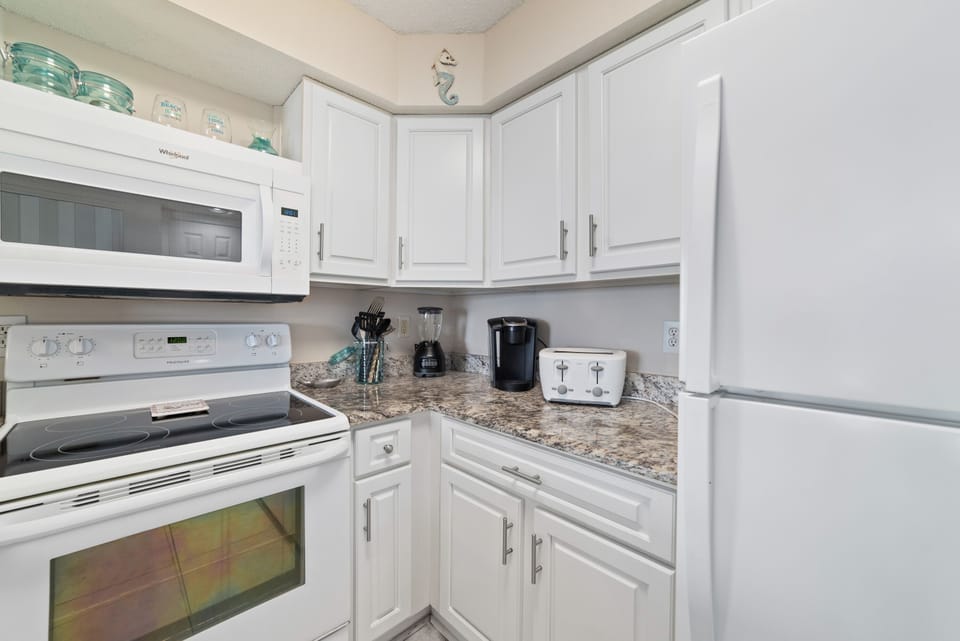 A tidy and functional kitchen countertop. This organized space, complete with coffee makers, a toaster, and a paper towel holder, makes everyday tasks a breeze.