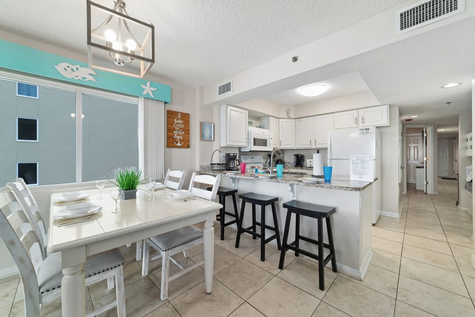 Dine in style with ample space for everyone. This inviting dining area features a charming table for family meals, complemented by additional seating at the convenient breakfast bar.