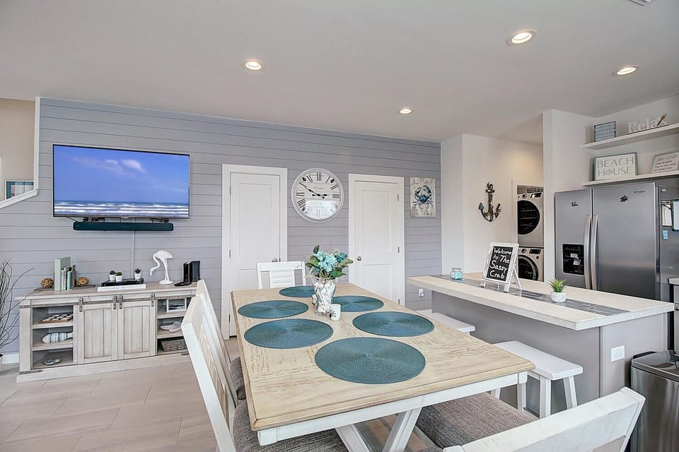 Your coastal-chic dining area flows seamlessly into the modern kitchen, complete with stainless steel appliances and entertainment center for memorable meals.