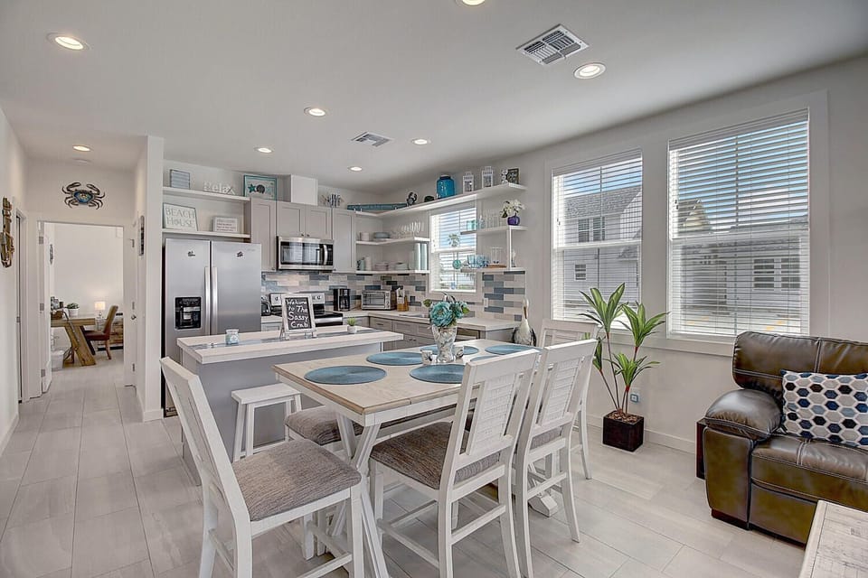 Your bright open kitchen features modern appliances and a spacious dining area where you'll gather for meals with ocean-themed touches throughout.