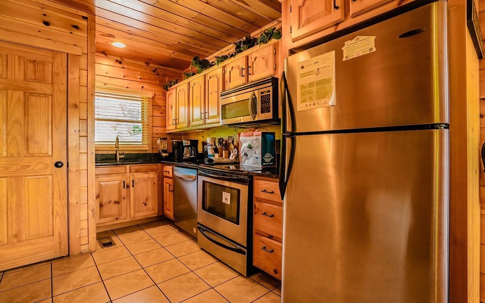 Fully equipped kitchen with stainless steel appliances and warm wood cabinets.