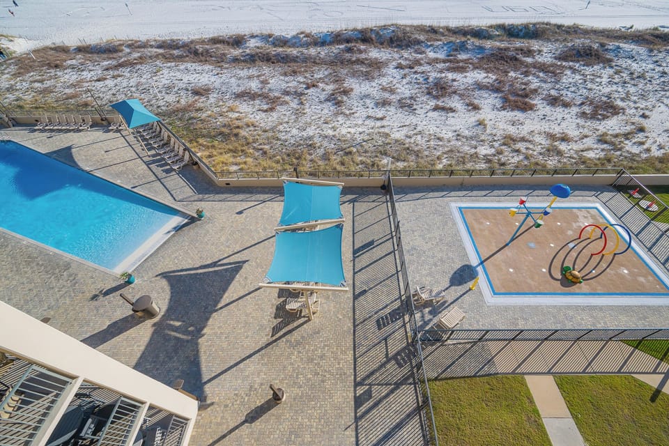 Watch kids splash with joy in the colorful splash pad next to the inviting poolside area