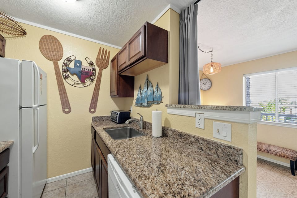 Step into your fully equipped kitchen, complete with granite countertops, rich wood cabinetry, and all the tools you need to whip up your favorite meals or morning coffee.