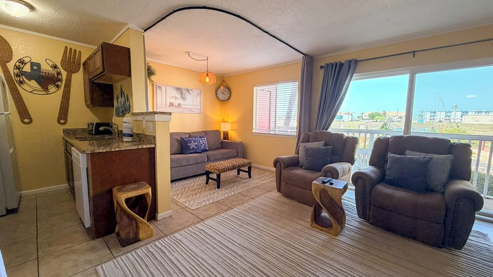 Open-concept living, dining, and kitchen layout complete with a sleeper sofa for extra sleeping space.