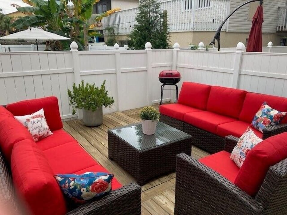 - Host casual cookouts with this cozy outdoor setup including a charcoal grill, plant decor, and comfy sofas
- Roomy fenced deck provides privacy and sunshine for your entire group
- Bright red cushions bring vibrant energy to your vacation vibe