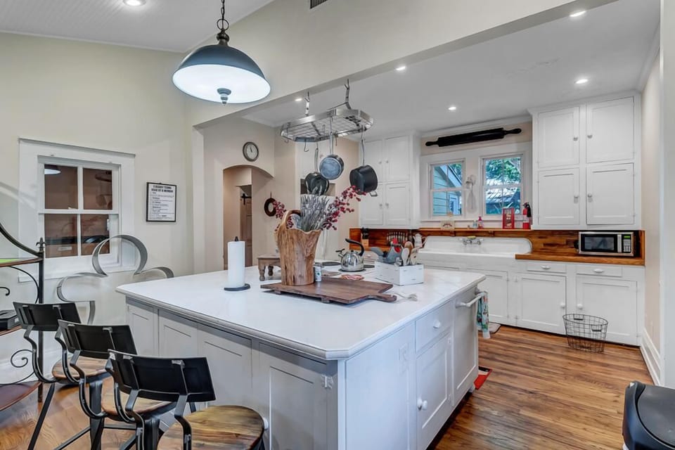 - Bright and spacious kitchen with large island, prep space, and casual dining stools
- Hanging light fixtures and classic shaker cabinets complete the inviting design
- Ideal for hosting, cooking, or simply enjoying a morning coffee together