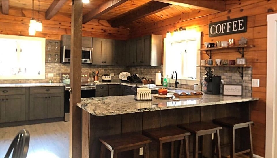 Large, roomy kitchen open to the living room with a barstool seating area. 