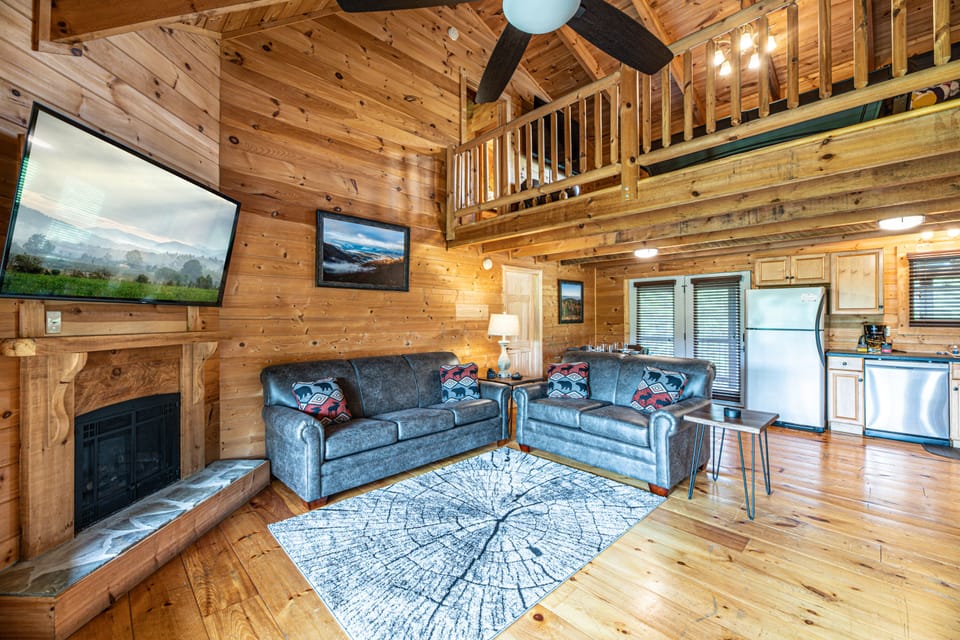 Living area with big TV on swivel wall mount. Premium leather couches.