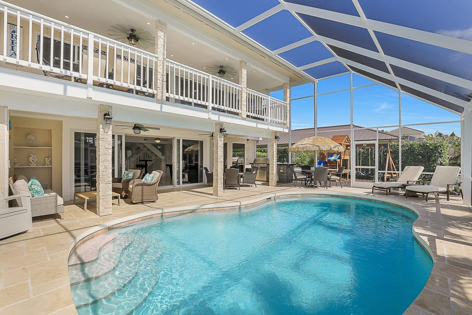 Pool view showing second floor Lanai, 1 floor seating area and outdoor kitchen