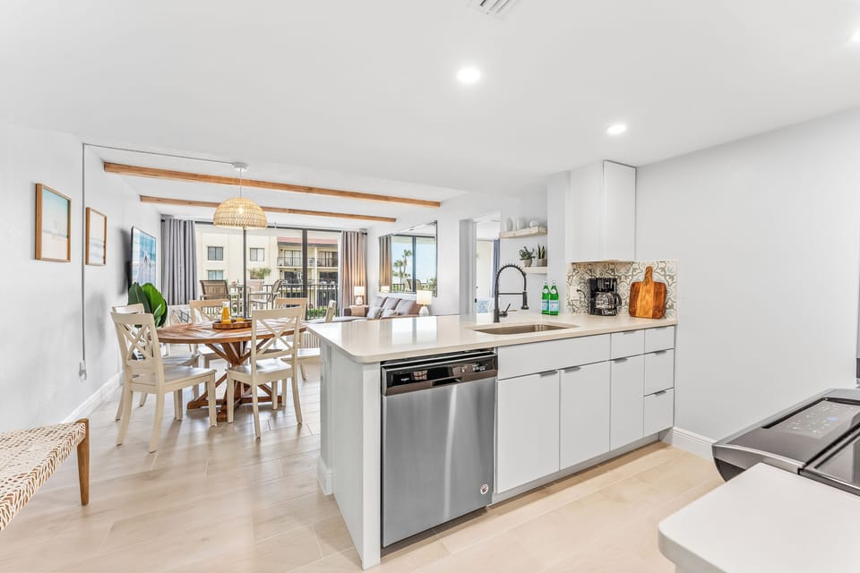 Modern kitchen with sleek stainless steel appliances, an open layout, and a view of the dining area.