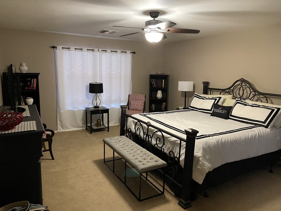 Large main bedroom with king bed, tv, and walk-in closet overlooking the pool 