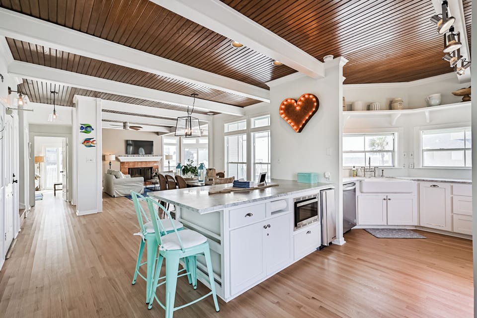 Island connects kitchen to rest of living space. Marble countertops.