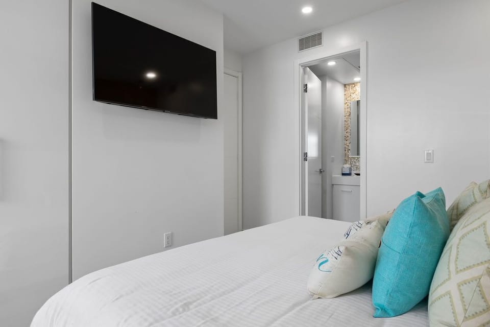 Your bright bedroom offers a plush bed, wall-mounted TV, and an ensuite bathroom—everything you need for a restful, convenient stay.