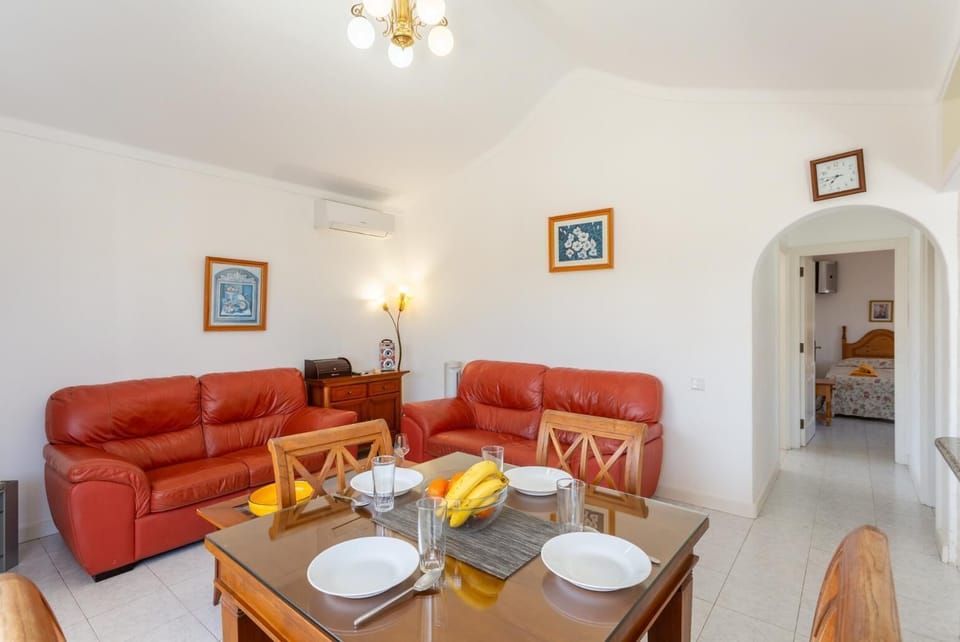 Open-plan living room with sofas, dining area, kitchen, A/C, WiFi internet, satellite TV, and terrace access